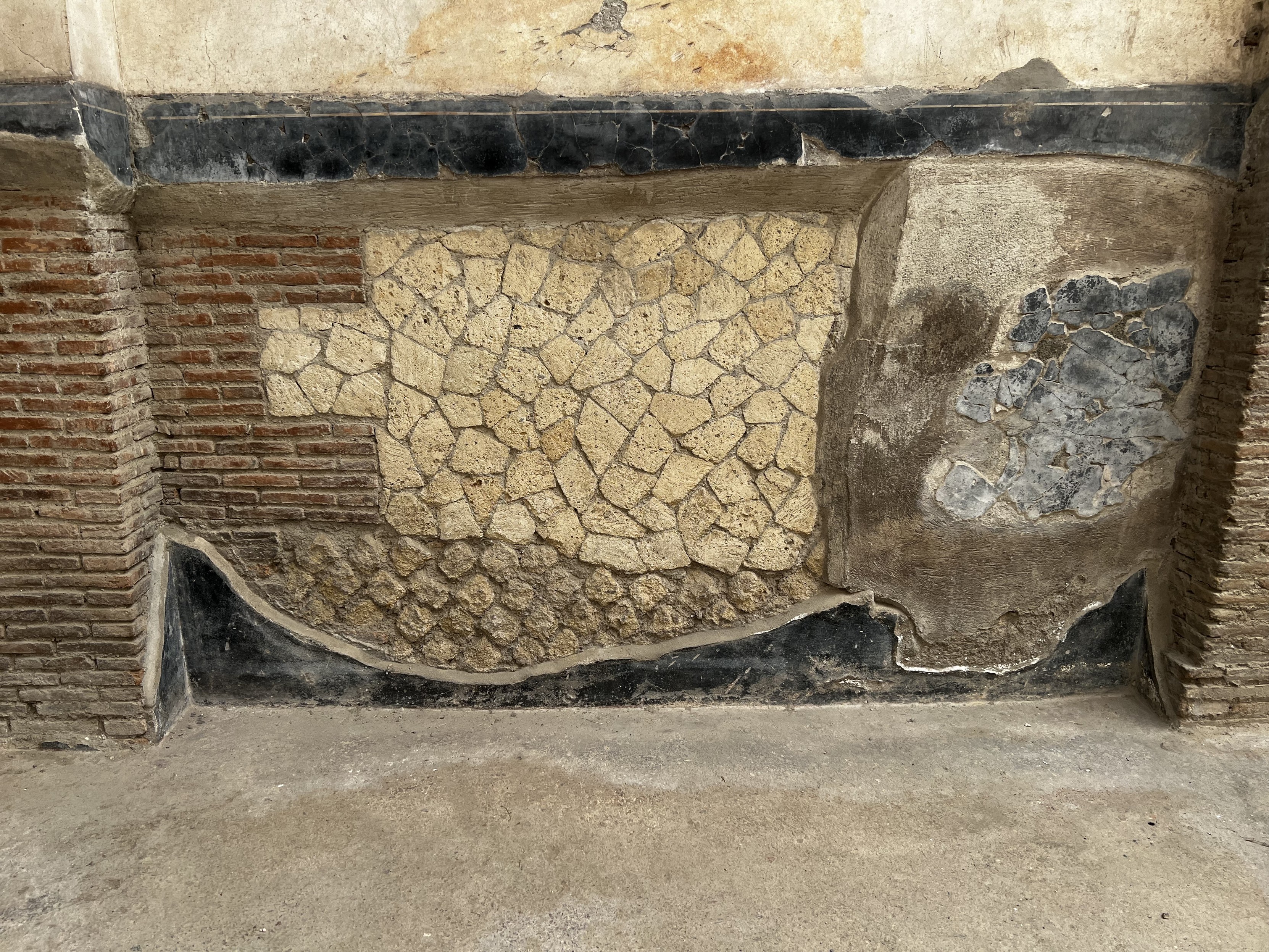 Photo of a wall, composed of at least 4 types of bricks, taken in Herculaneum.