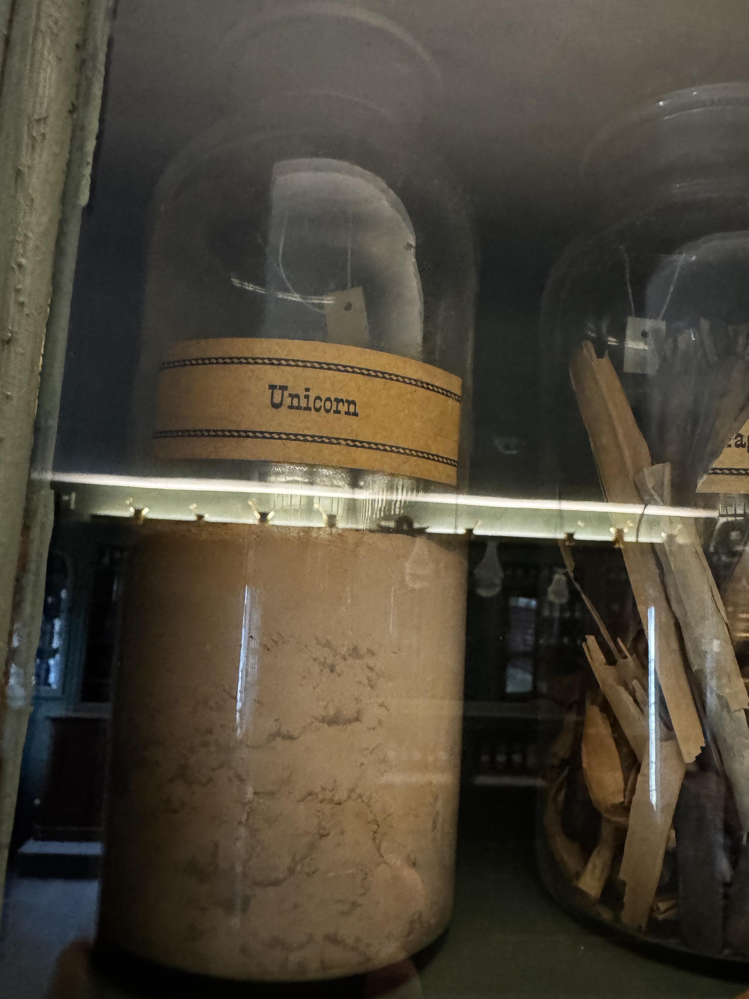 An apothecary jar labeled “Unicorn”. 
